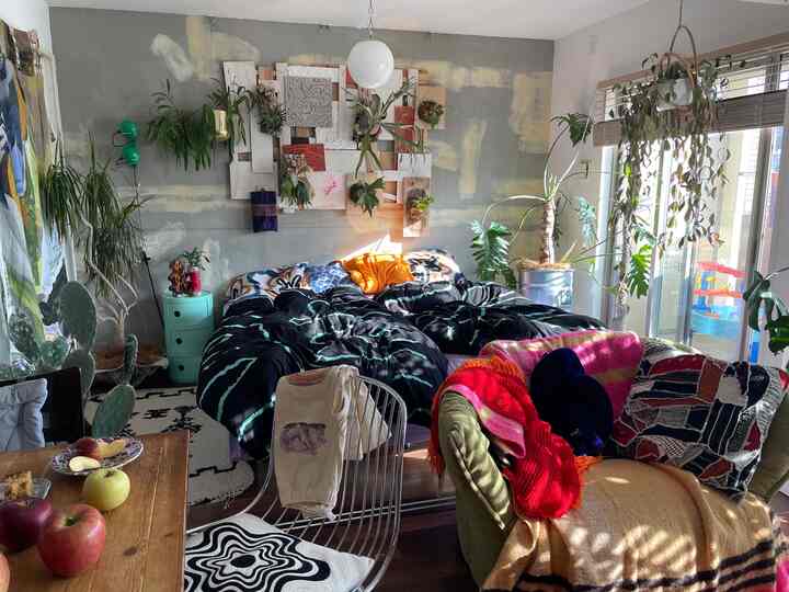 Sunlit natural bedroom featuring abundant plants and a textured sofa creating a cozy atmosphere