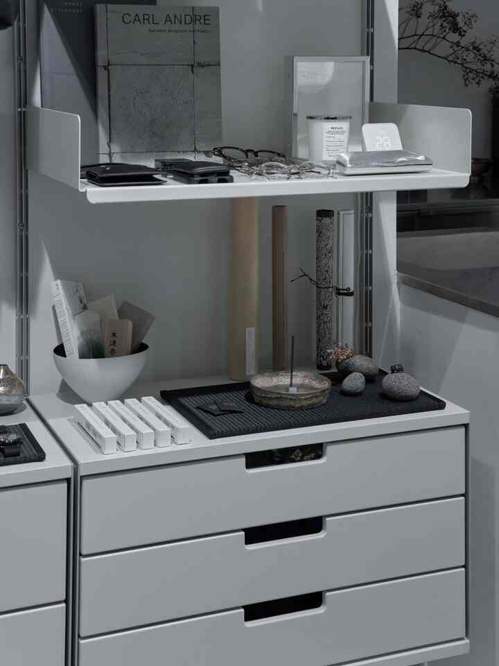 白を基調としたナチュラルカラーが調和するモダンな収納棚にキャンドルとトレイが配置された雰囲気のあるインテリア