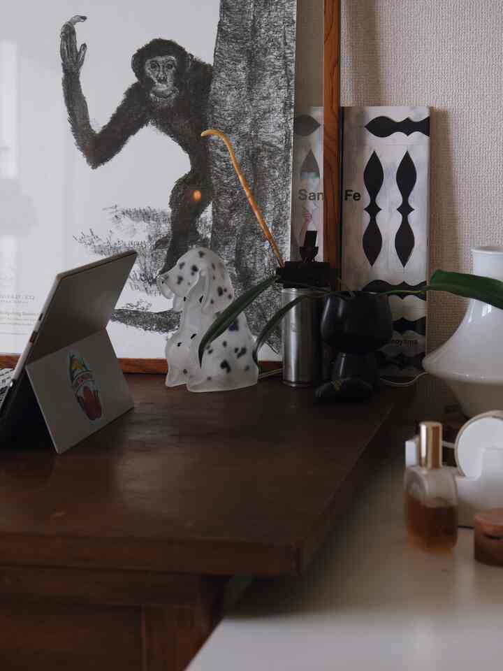 A brown-toned desk with a plant and dog-shaped lamp in an indoor workspace