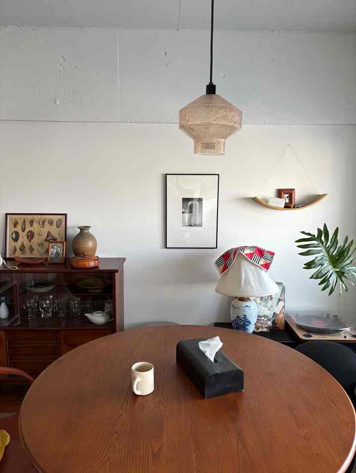 Wood-toned and black accented living room with a round dining table and vintage furniture, creating a cozy atmosphere