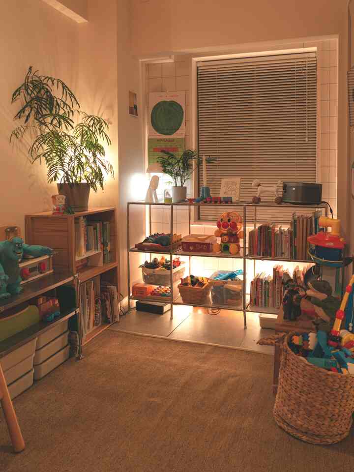 Warm indirect lighting in a natural-tone kids' room featuring shelves organized with toys and books creating a cozy atmosphere