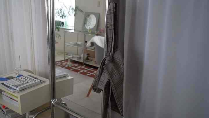 シルバーフレームの全身鏡が配置された、ナチュラルな色調の落ち着いたリビングのインテリア