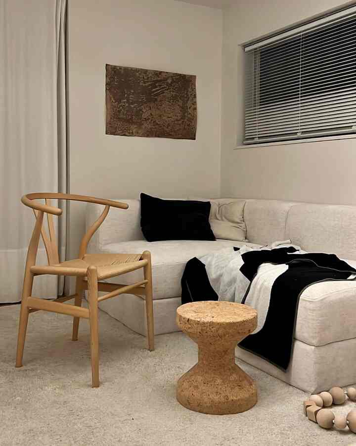 白とベージュのトーンが印象的なリビング、2人用モジュラーソファと木製アームチェアが配置されたナチュラルモダンなインテリア