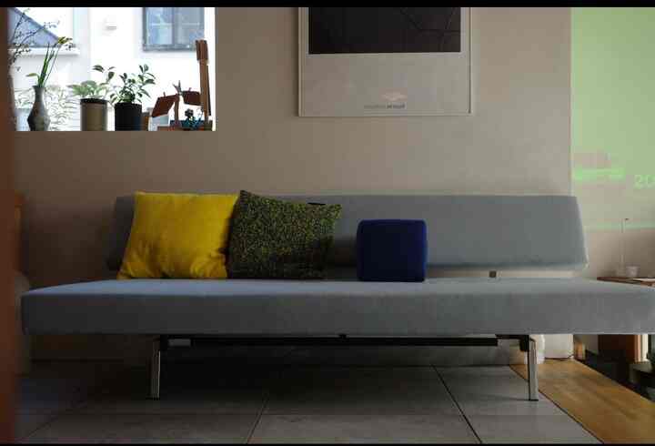 Natural-toned modern living room featuring a light gray sofa with colorful cushions in a clean, minimal setting