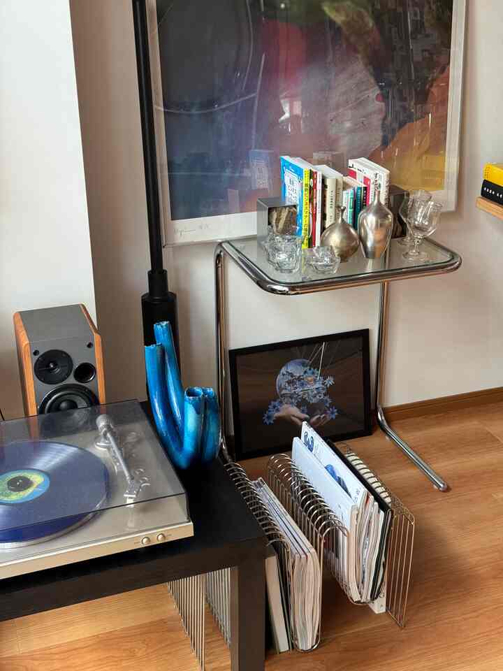 青色のアクセントが配置された一人暮らしの空間、ターンテーブルとアート作品が調和する印象的なインテリア