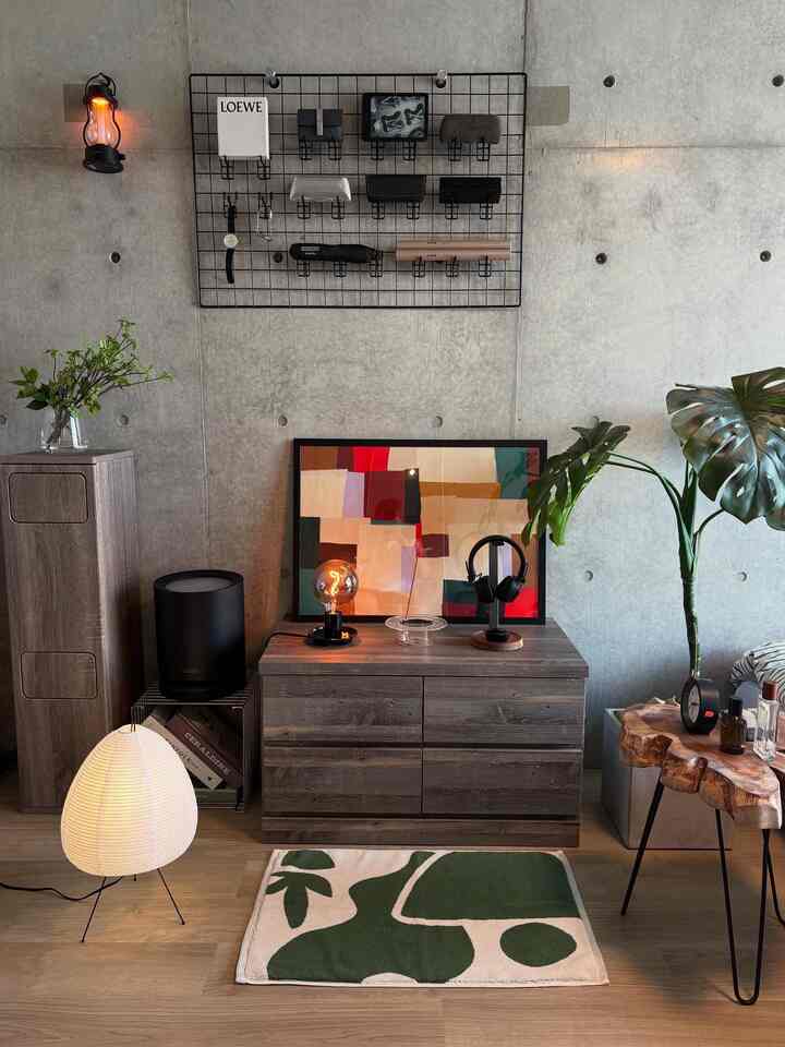 Calm gray concrete wall and natural brown wood furniture, plants and art poster blend in a single household living room space