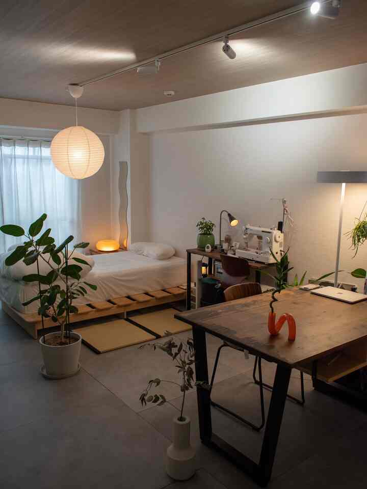 Beige and brown toned studio apartment featuring a wooden bed and desk with cozy natural atmosphere