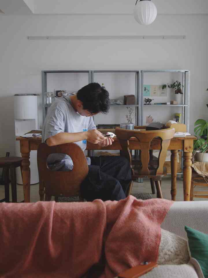 White-walled dining room featuring brown wooden dining table and chairs, natural vintage ambiance