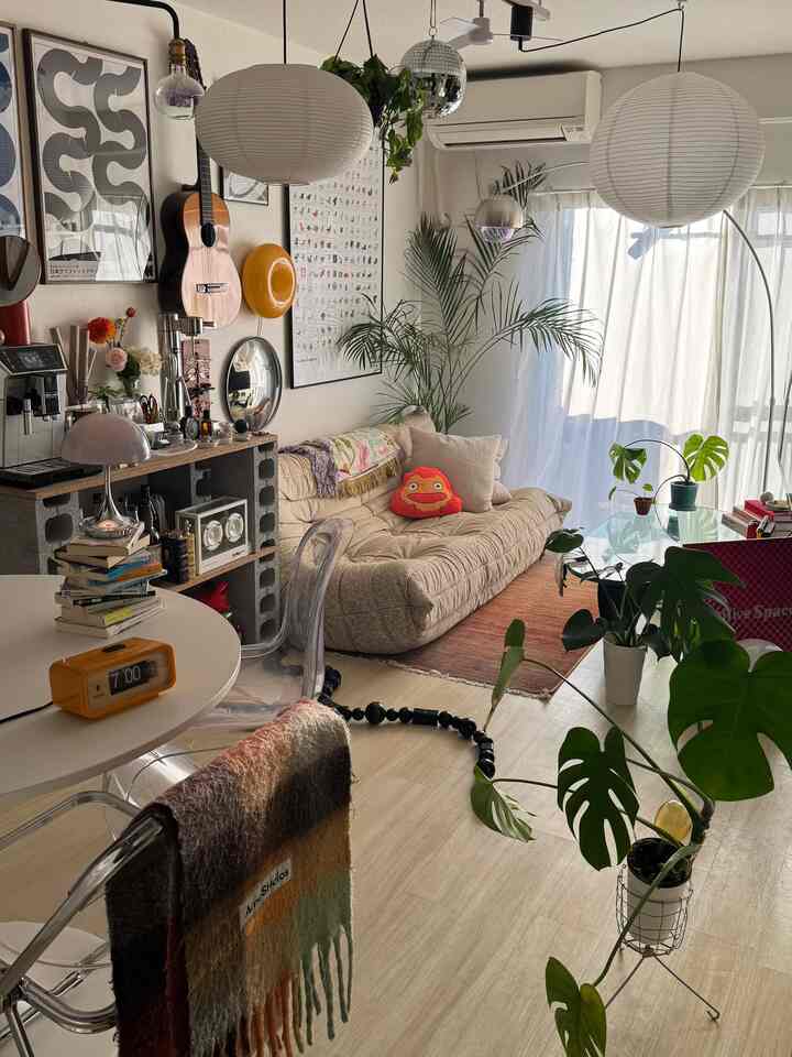 ナチュラルカラーとモノトーンが調和したリビング、くつろげるソファと植物が配置された雰囲気のあるインテリア