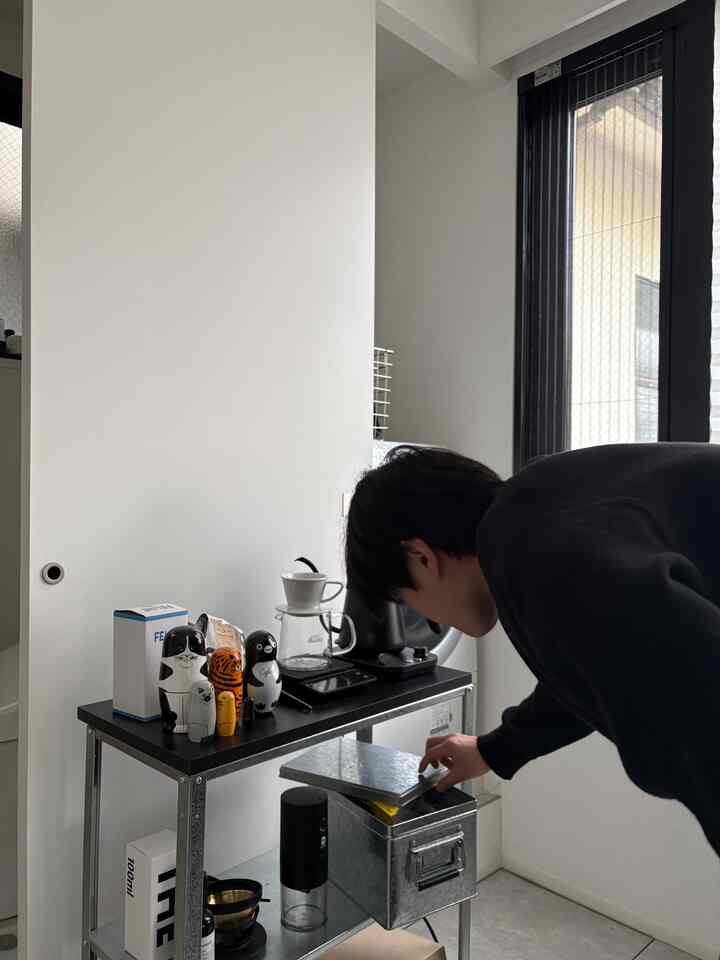 グレーと黒のトーンが調和する狭いダイニングスペースに、収納アイデアの金属棚とおうちカフェが配置された雰囲気のあるインテリア