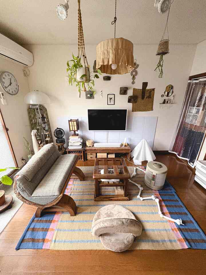 ナチュラルな色調のリビング、木製ソファとラグが配置されたモダンで落ち着いた雰囲気のインテリア