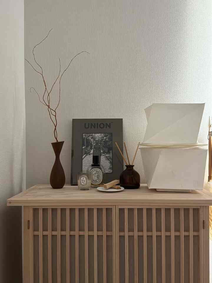 Natural tone wooden lattice cabinet topped with various objets in a warm, cozy setting