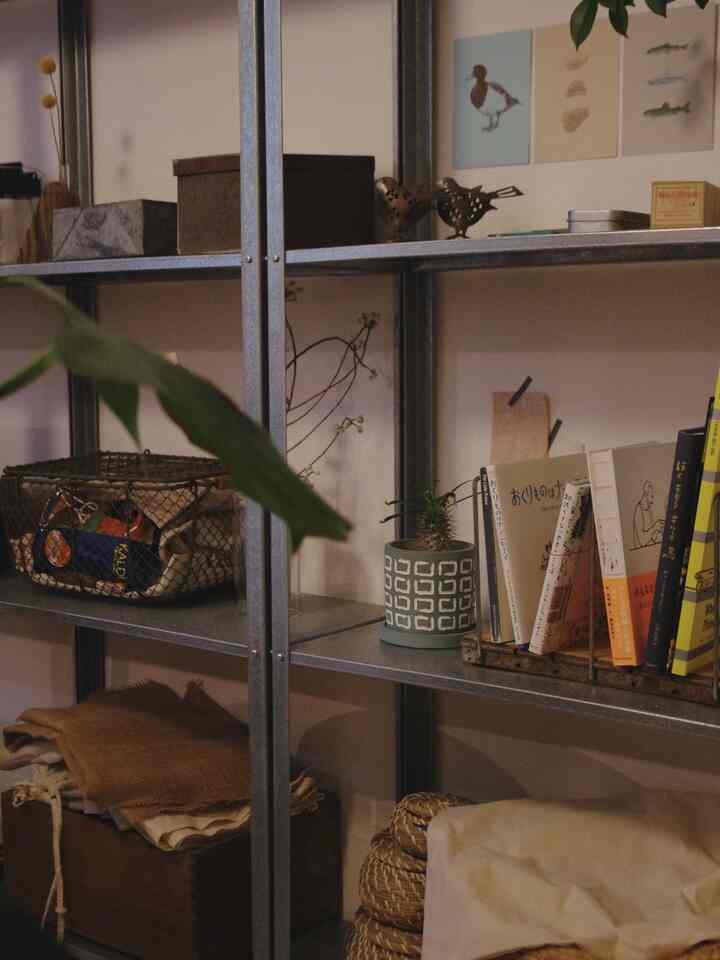 Natural-toned dining room featuring a metal shelving unit filled with organized storage and vintage items, creating a cozy atmosphere