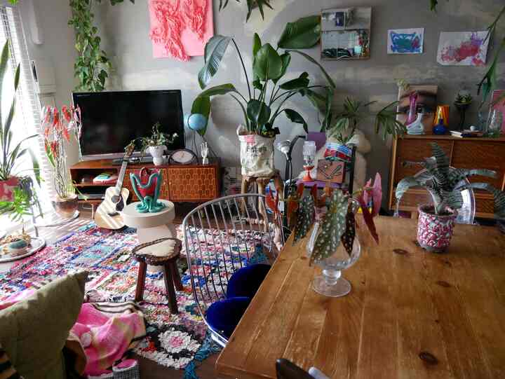 緑色の植物と木目調家具が配置された、ナチュラルで落ち着いた雰囲気のリビング