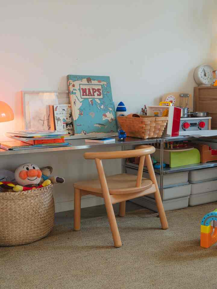 ナチュラルな色合いの子供部屋、ステンレス棚と木製の机、ぬいぐるみなどが配置された雰囲気のあるインテリア