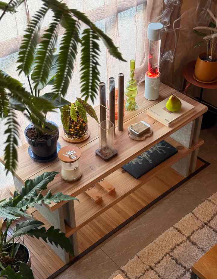 ナチュラルな木目調と植物が配置された、温かみのあるインテリアアクセサリーが並ぶ棚の空間