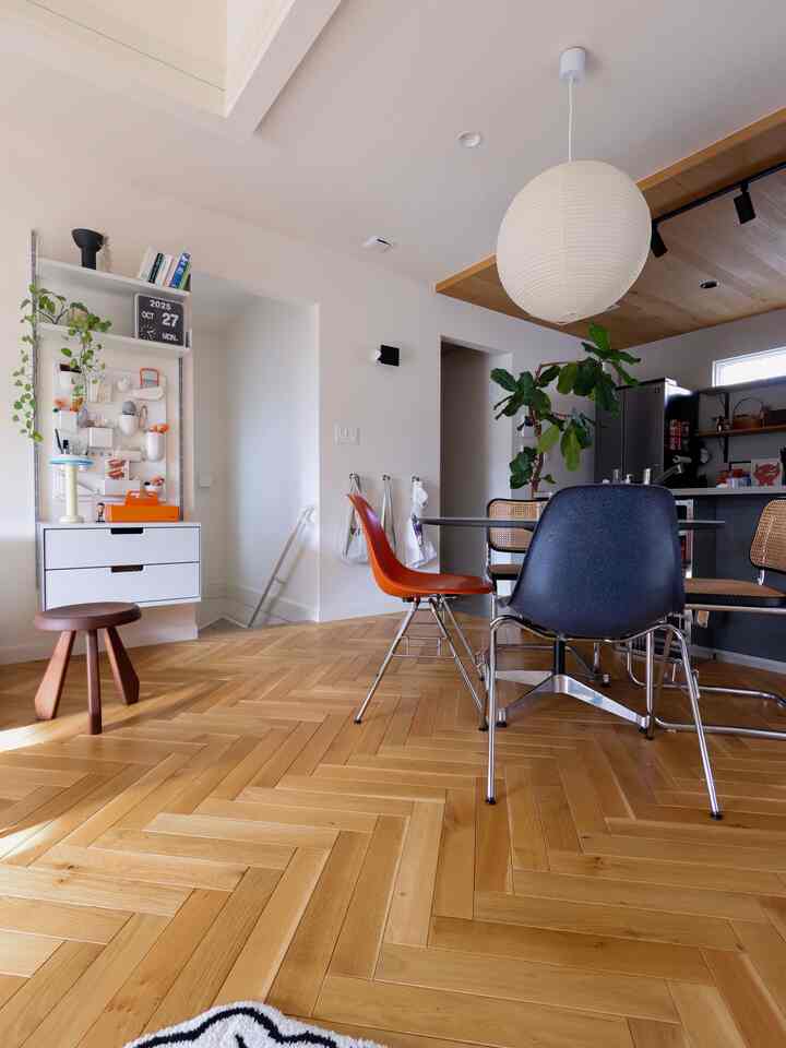 White and wood tone Mid-Century Modern dining room featuring pendant light and dining chairs with warm atmosphere
