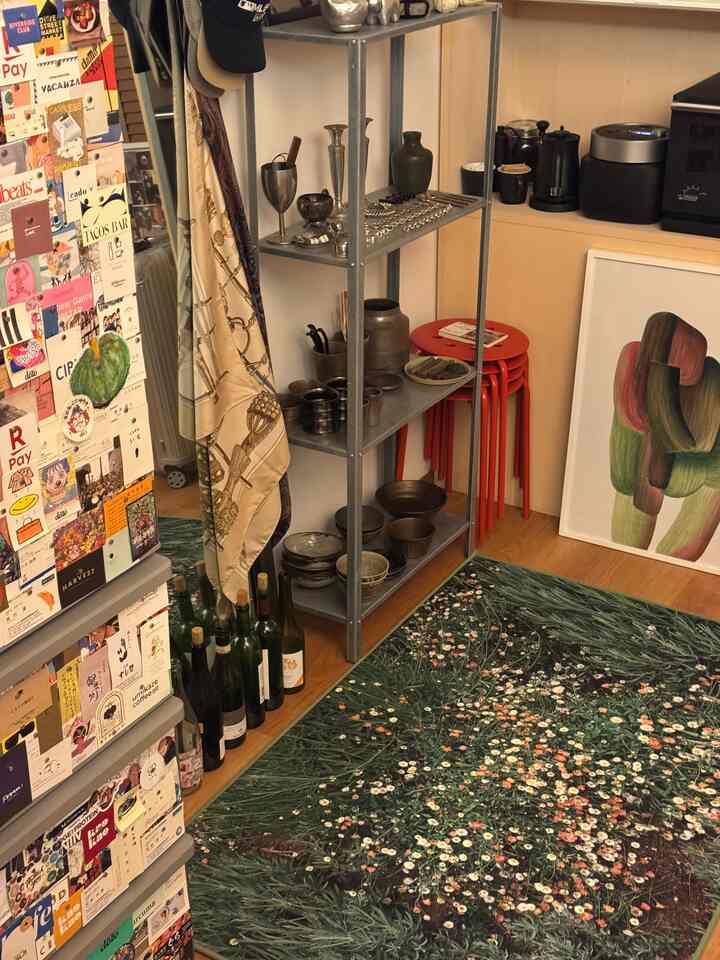 ナチュラルカラーのキッチンスペース、赤いスツールと花柄のラグが印象的な温かみのあるインテリア