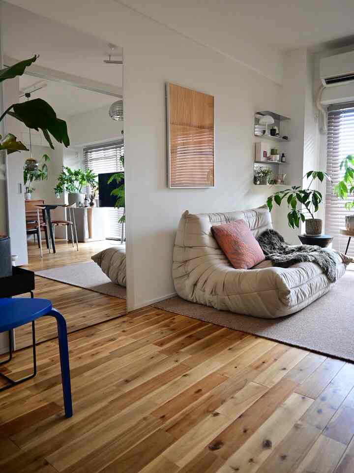 Natural-toned living room featuring a large full-length mirror and beige sofa, creating a warm and cozy interior