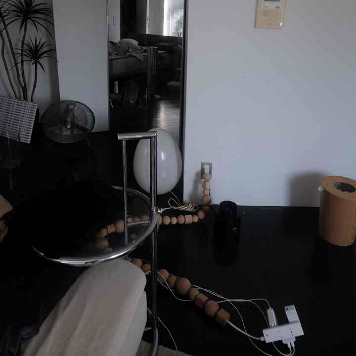 Clean natural modern home office with black floor and metal frame desk featuring cable organizer and light wood accents