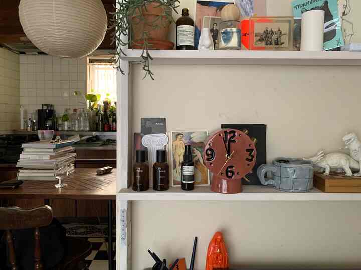 ナチュラルな色調のキッチンとヴィンテージ風の小物が並ぶ雰囲気のある棚のインテリア