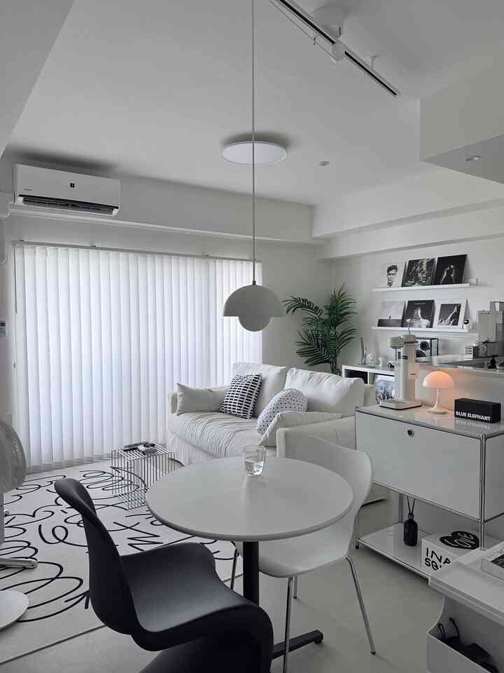 ホワイトトーンのリビングとダイニング、シンプルでモダンな家具とペンダントライトが配置された印象的な空間