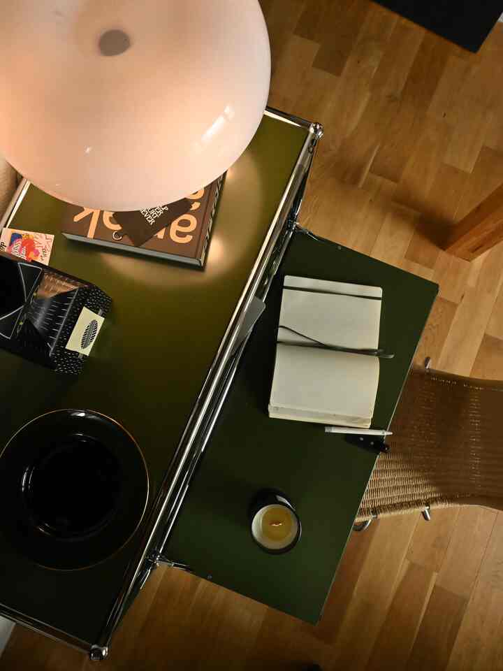 ウッドトーンの床とグリーンのキャビネットが配置されたシンプルなデスク空間、落ち着いた雰囲気のインテリア