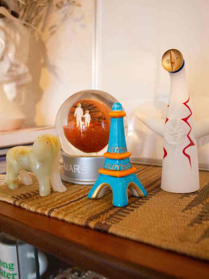 ブラウンの木目調と白い背景のリビングに、ミッドセンチュリーモダンスタイルのカラフルなオブジェが並ぶ雰囲気のあるインテリア