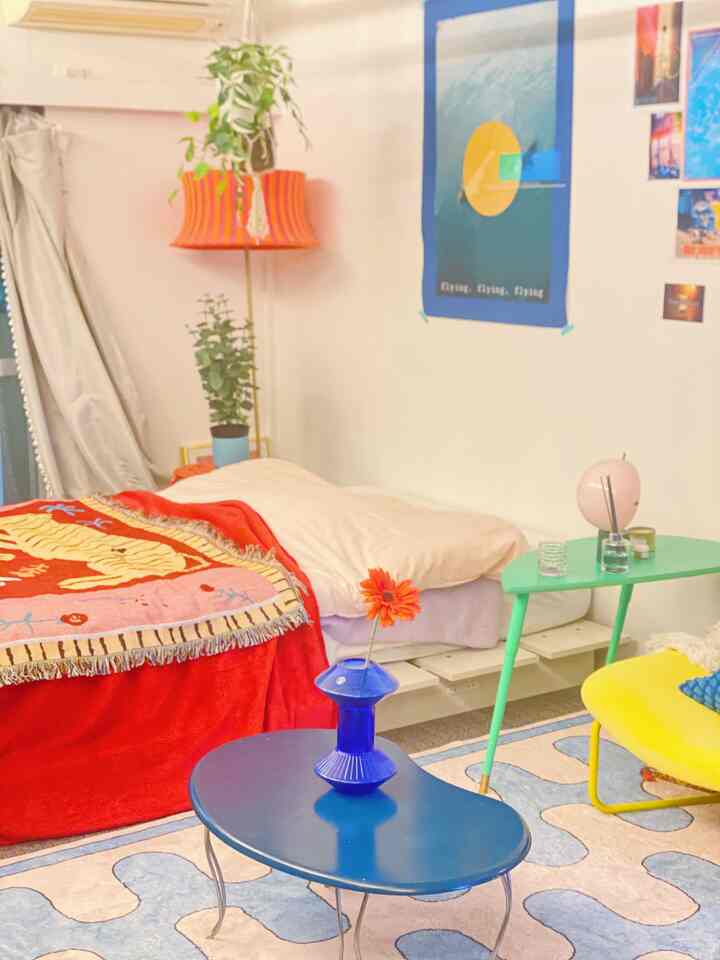 A pink and red toned single household bedroom with Nordic style, cozy living room atmosphere featuring bed and colorful furniture