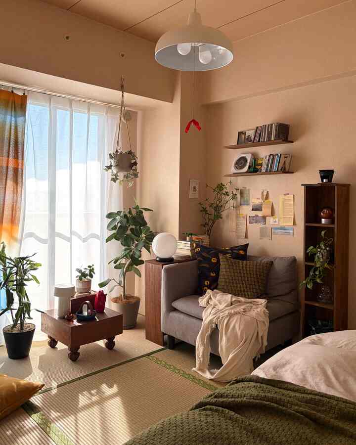 暖かいベージュ調の6畳和モダンリビング、グレーのソファと植物が配置された雰囲気のある空間