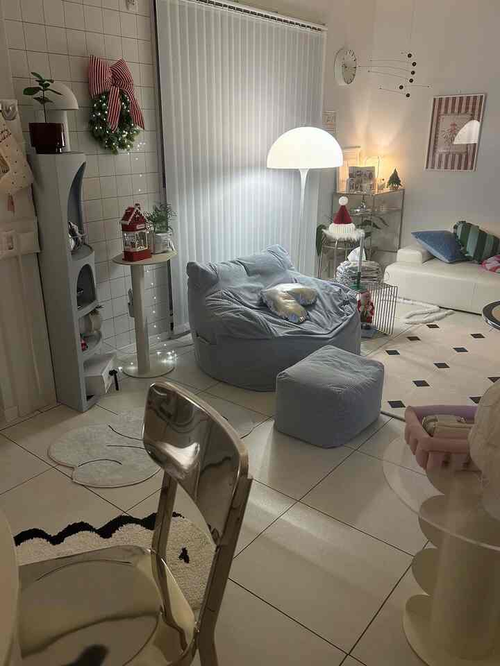 ホワイトとベージュのトーンのリビング、ブルーのビーズクッションとホワイトソファ、クリスマス装飾が置かれた雰囲気のあるインテリア