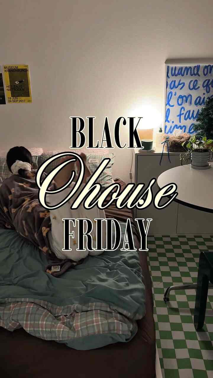 Natural toned bedroom featuring a cozy blanket-covered bed centered, with plants and table lamp creating warm atmosphere