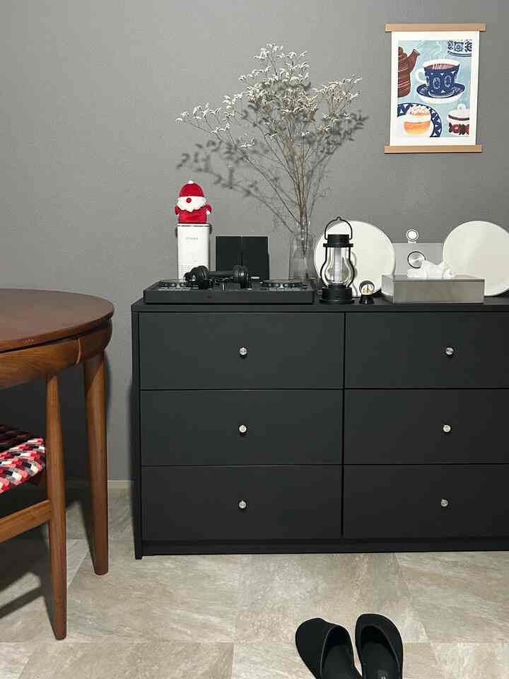 グレーの壁と黒いチェストが配置された1LDKの二人暮らし向け、シンプルな韓国風インテリアの空間