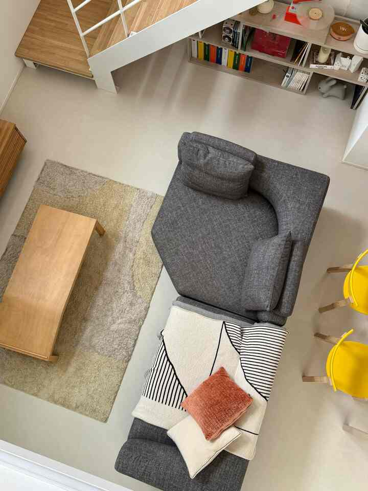 Nordic living room featuring natural wood tones and a gray sectional sofa with minimalist design