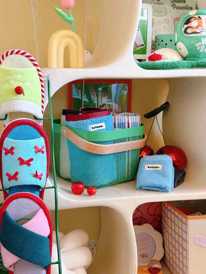 Cozy and cute storage space featuring white shelves and a green storage basket