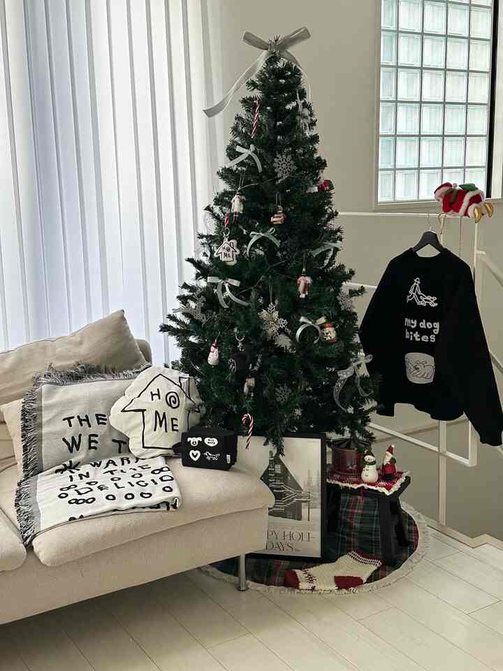 白とベージュのトーンの1LDKリビング、中央にクリスマスツリーとベージュのソファが配置された雰囲気のある空間