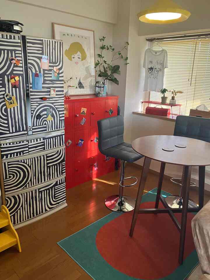 赤と緑の色調のダイニングルーム、バースツールと丸テーブルが配置された雰囲気のあるカフェ風インテリア