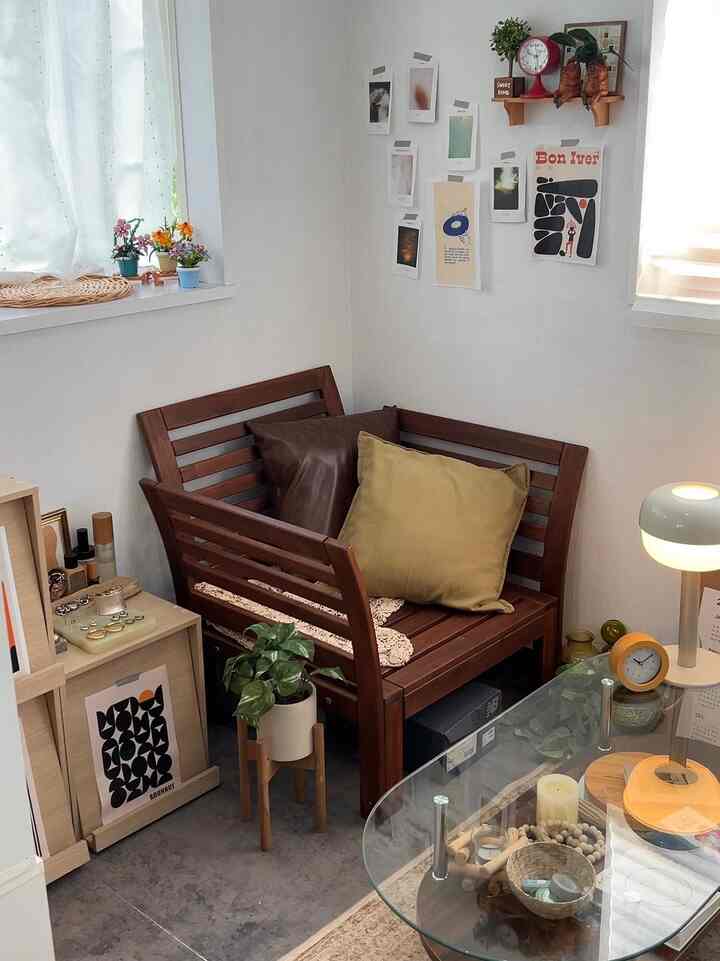 Natural wood-toned living room corner with white walls featuring an armchair and glass coffee table, creating a cozy atmosphere