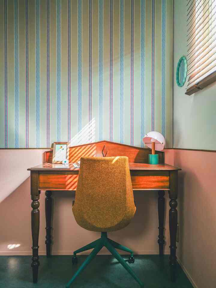 温かみのあるブラウンとナチュラルカラーのヴィンテージワークスペース、木製デスクとオフィスチェアが配置された雰囲気のあるインテリア