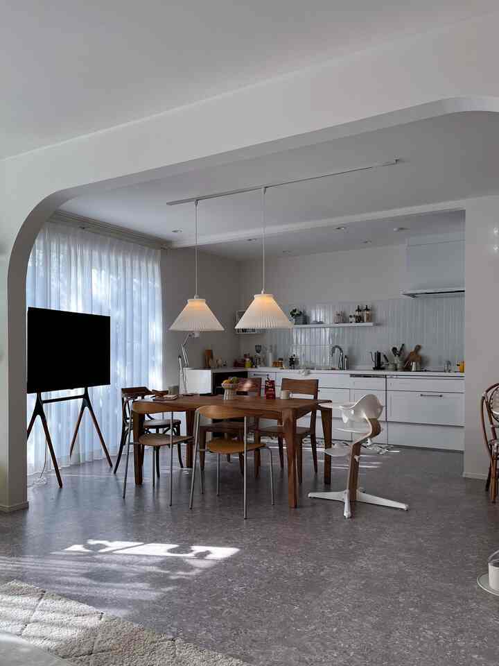 白と木目調が調和したダイニング、ダイニングテーブルとテレビ台が配置されたモダンな家族空間