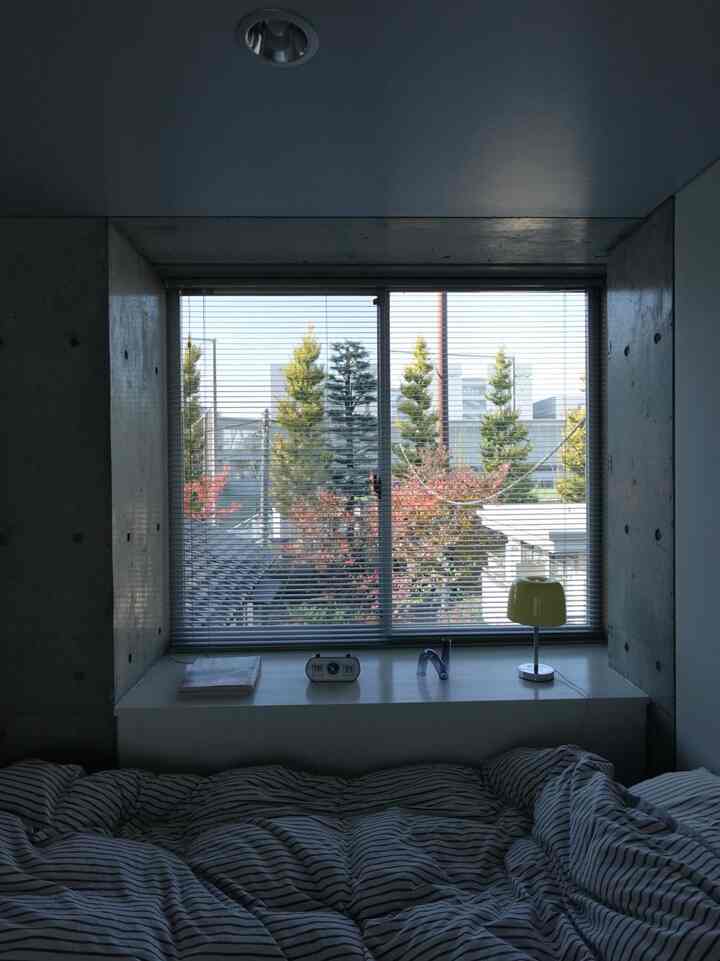 Monotone small bedroom featuring a window desk and blinds with a calm atmosphere