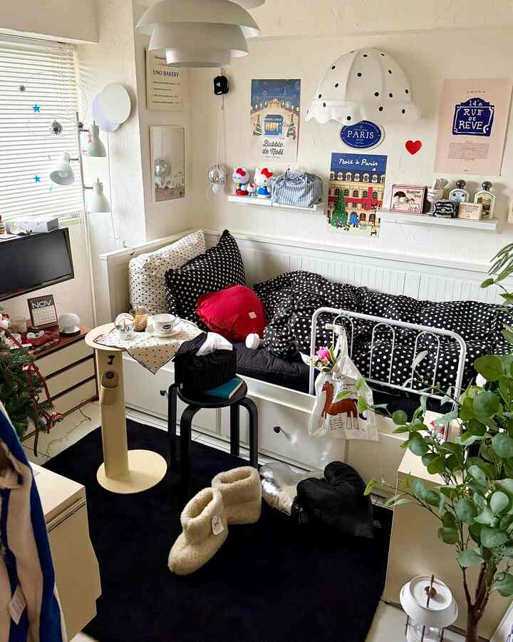 Cozy bedroom with white and black polka dot bedding accented by a red heart-shaped cushion