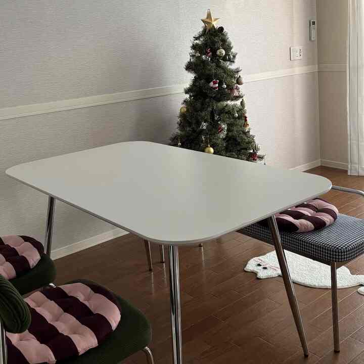 ブラウンの床にホワイトテーブルとグリーンのクリスマスツリーが配置された雰囲気のあるダイニングルーム