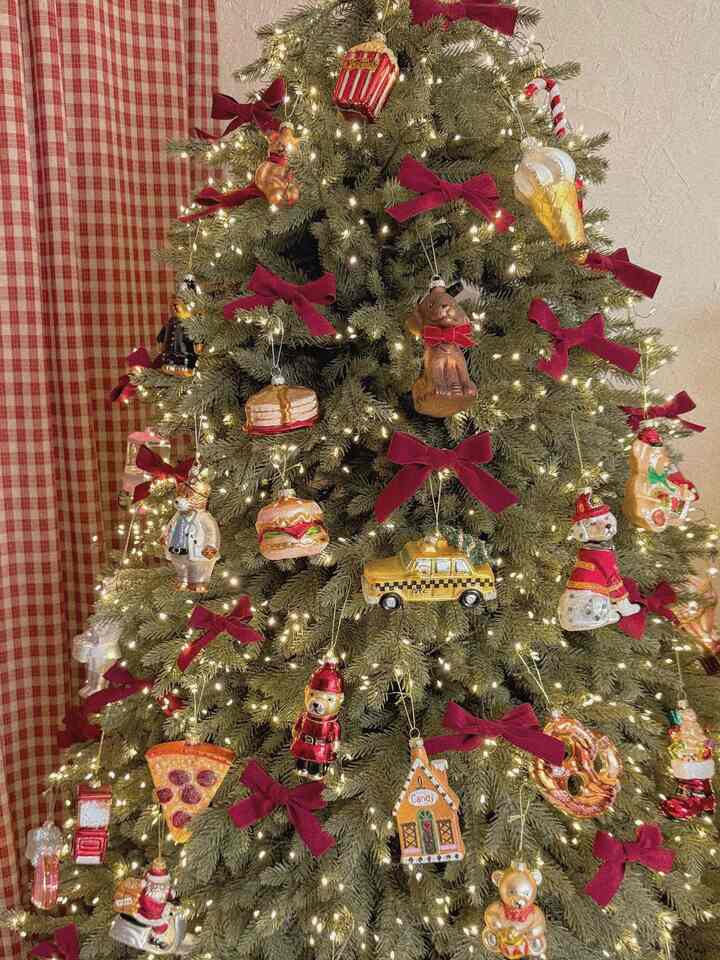 Cozy space featuring a Christmas tree decorated with red bows and golden garlands lighting