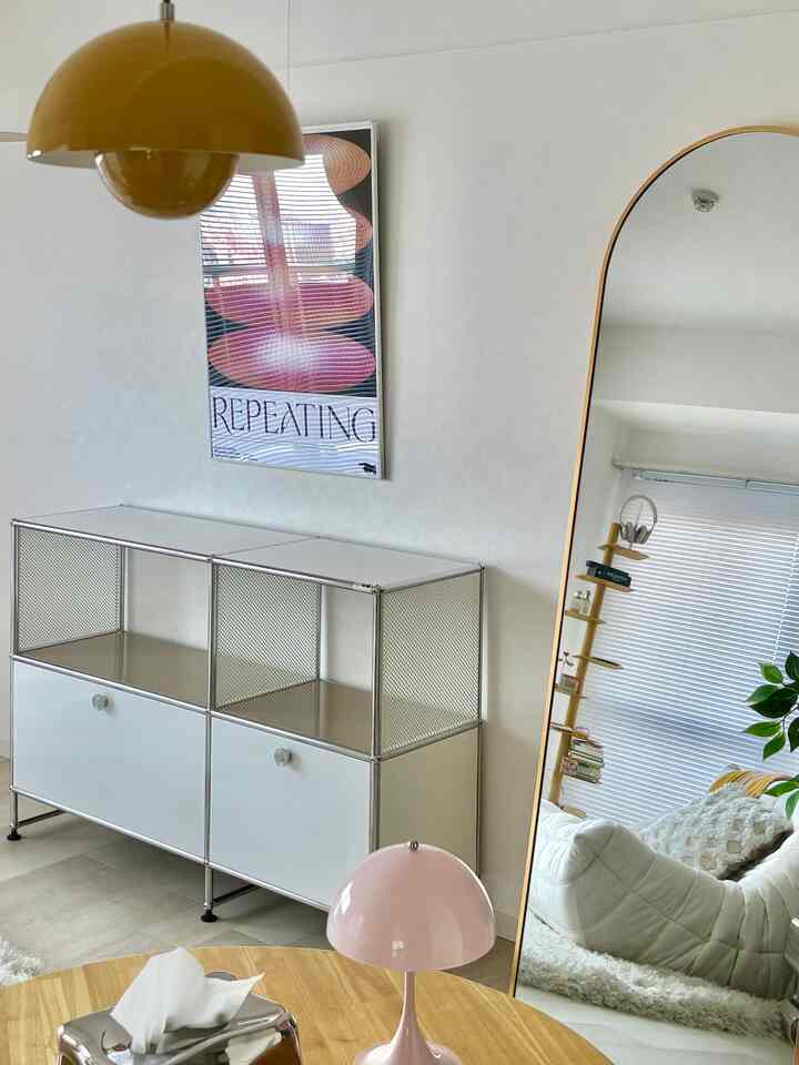 白とナチュラルカラーのリビング、USM HALLER収納キャビネットと木製テーブルが配置されたミニマルで整った空間