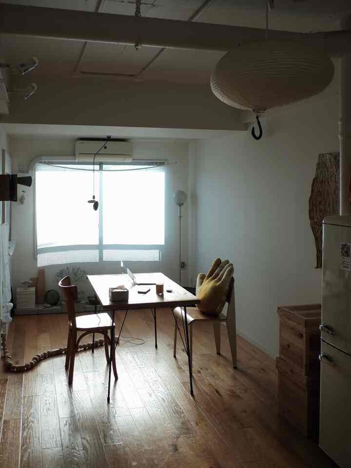 白い壁と木目調の床のナチュラルなリビング、木製ダイニングテーブルと椅子が配置された落ち着いた雰囲気のインテリア