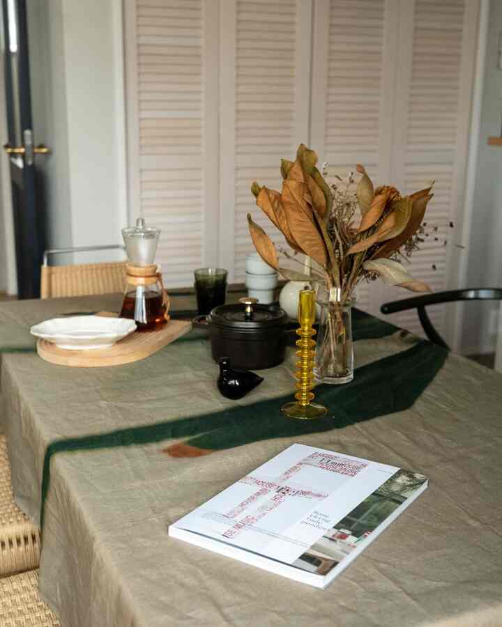 Natural beige and wood-tone dining table with a linen tablecloth and vintage-styled decor creating a cozy atmosphere