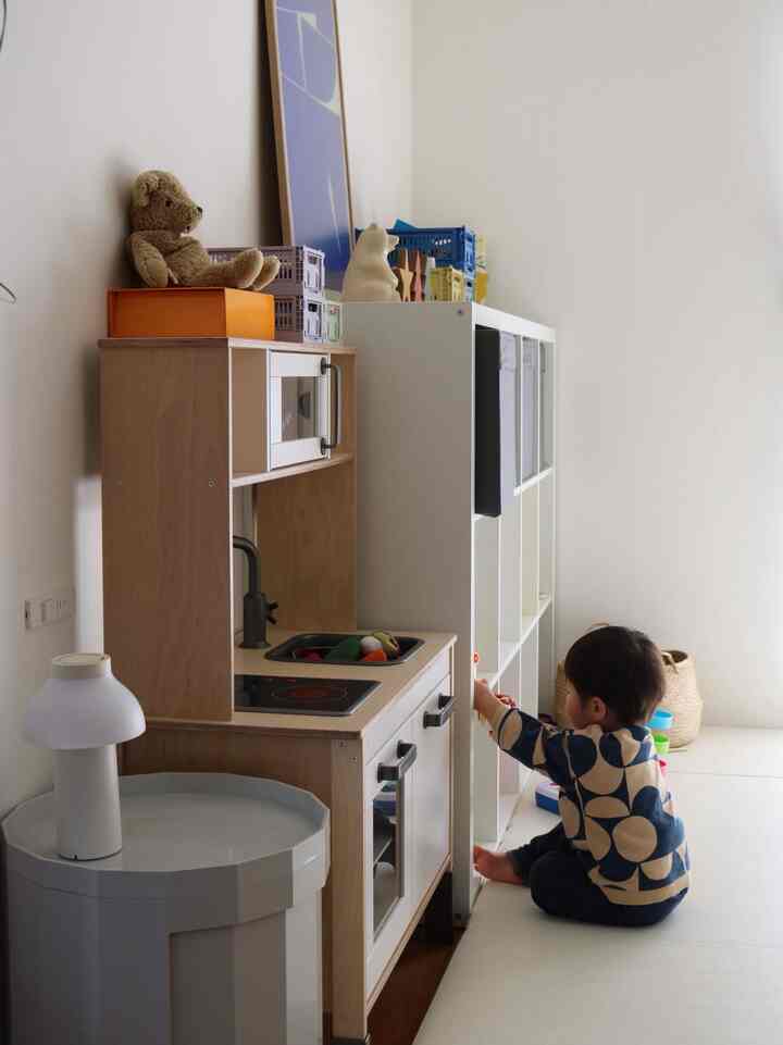 白と木目調の子供部屋、IKEAのカラックスおもちゃ収納と遊ぶ子供がいるシンプルで落ち着いた雰囲気のインテリア