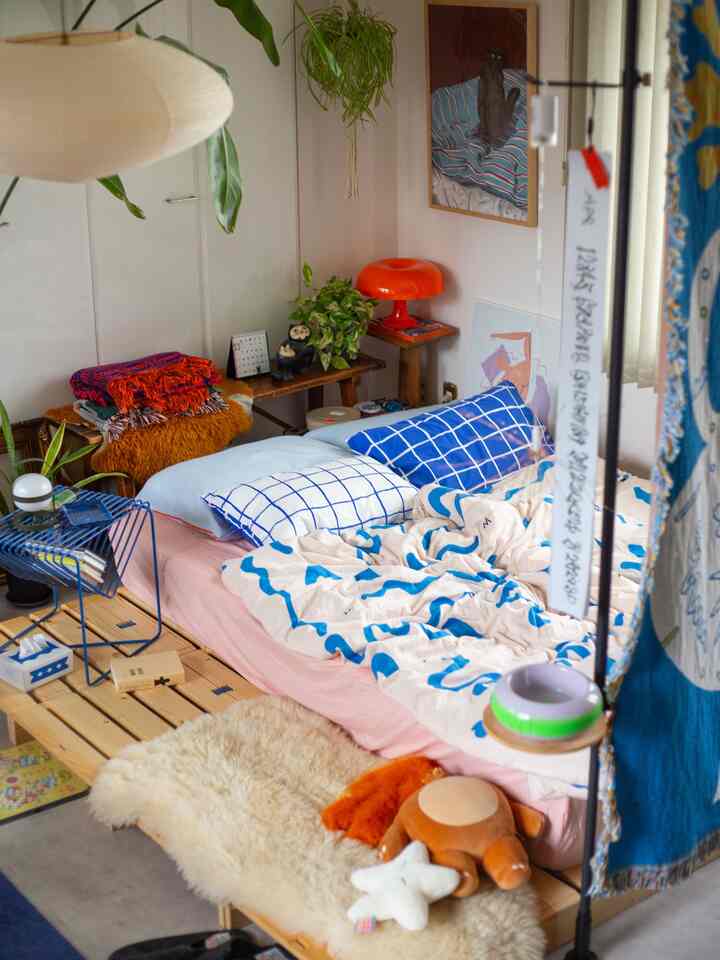 パステルのピンクとブルーが調和する寝室、自然素材とミッドセンチュリーモダン家具が配置された温かみのある空間