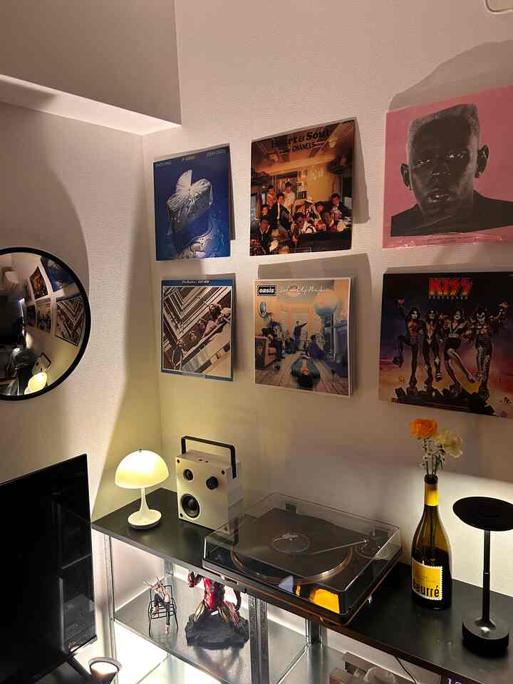 ブラックとホワイトのトーンでまとめられたワンルーム寝室の一角、レコードと照明が置かれたレトロな雰囲気のあるインテリア